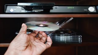 Woman putting a DVD into a player