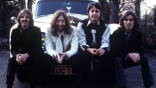 The Beatles sit on a white Rolls Royce