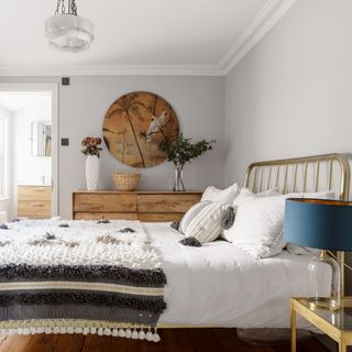 Bedroom with door to en suite and brass bed with tasselled bedcover