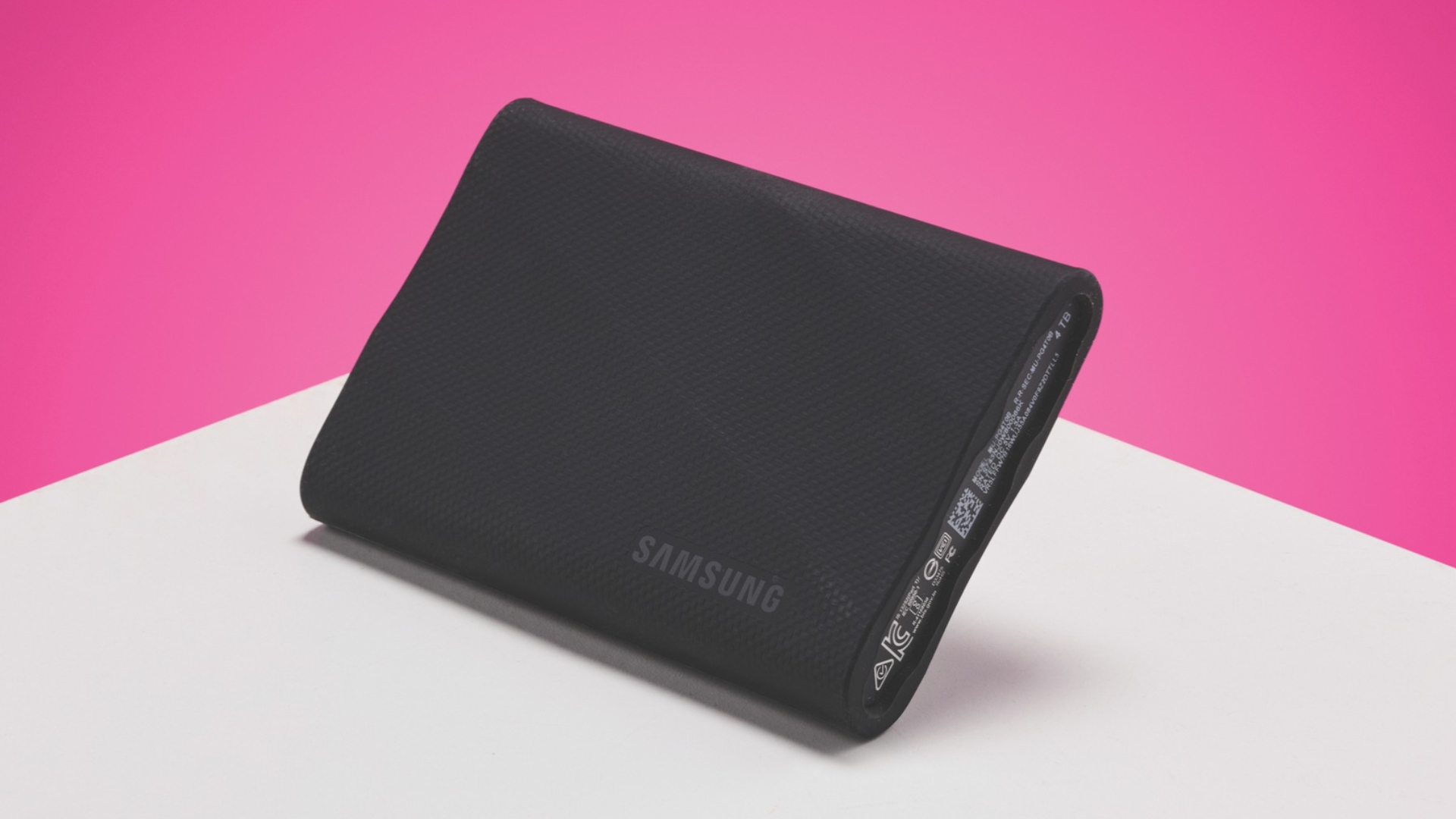 A Samsung T9 external hard drive on a white and pink background