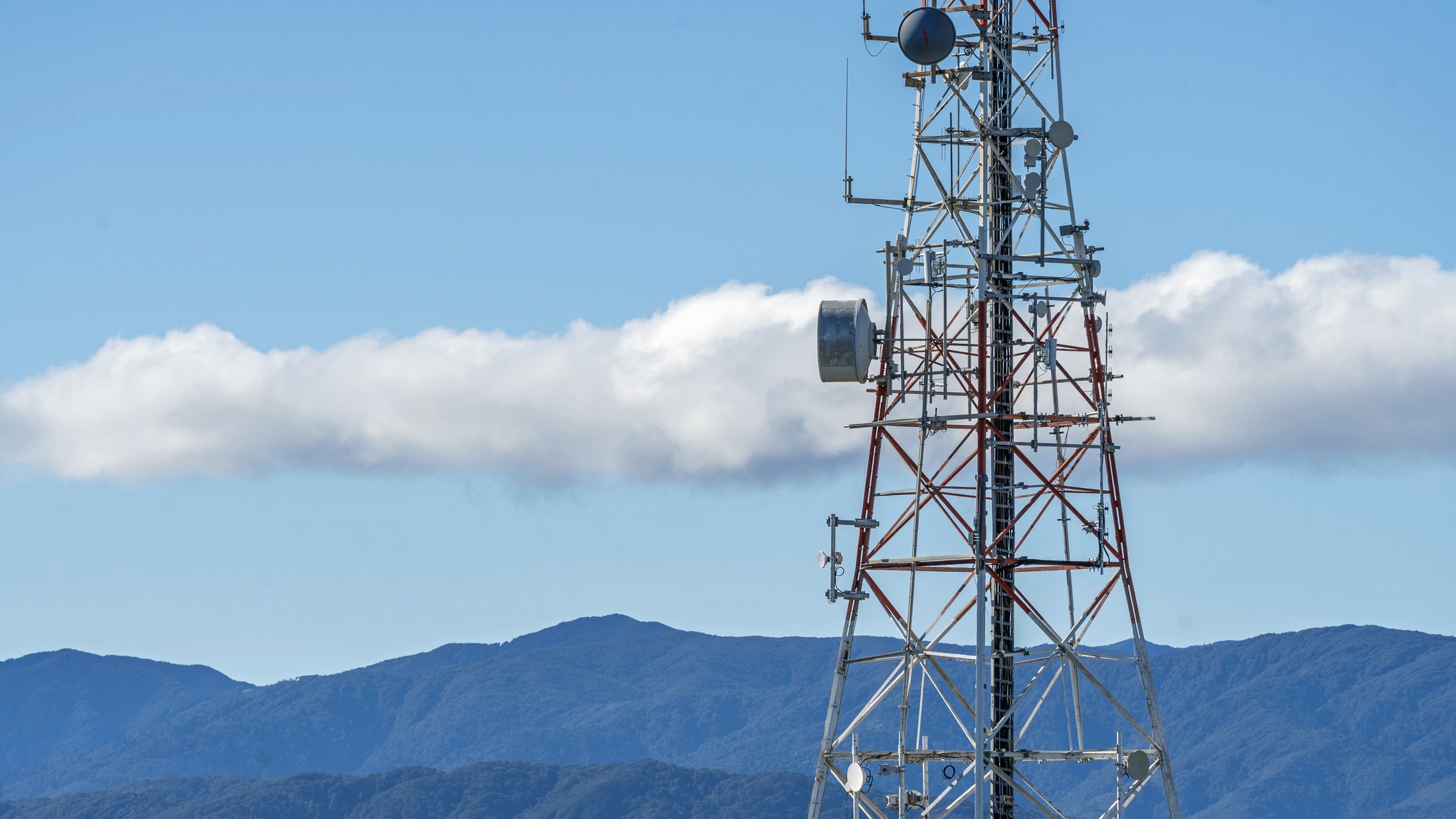 A radio tower with mountains in the background