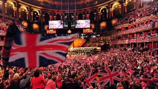 People wave flags at the Royal Albert Hall in west London on September 7, 2013 during the last night of the Proms. US conductor Marin Alsop became the first woman to conduct the Last Night of the Proms in its 118-year history. AFP PHOTO/CARL COURT (Photo credit should read CARL COURT/AFP via Getty Images)