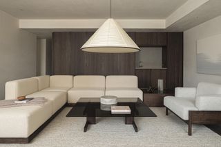 A living room in the Karimoku Case Study house furnished with cream corner sofa and pendant lamp