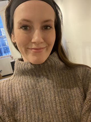 senior editor Halie LeSavage wearing a sweater and a full face of fenty beauty makeup