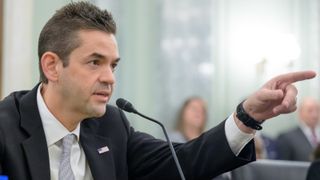 A man points his finger at the right of the screen.