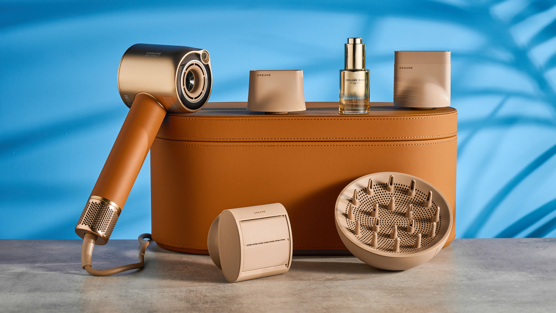 the dreame miracle pro hair dryer in gold showing the storage box on the blue tom's guide background, with the four attachment nozzles including two blow-drying nozzles, diffuser, and the flyaway tamer