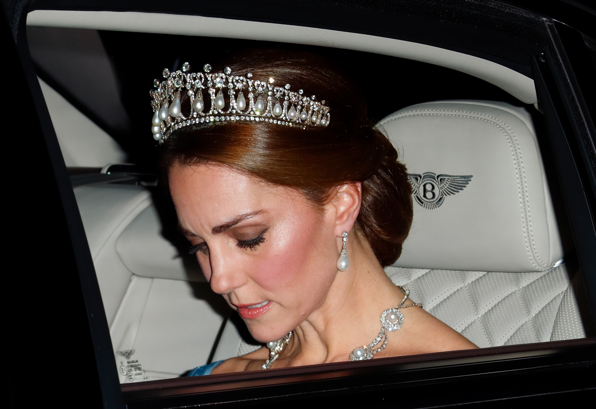 Princess Kate wears the Lover's Knot tiara riding in a car and looking down