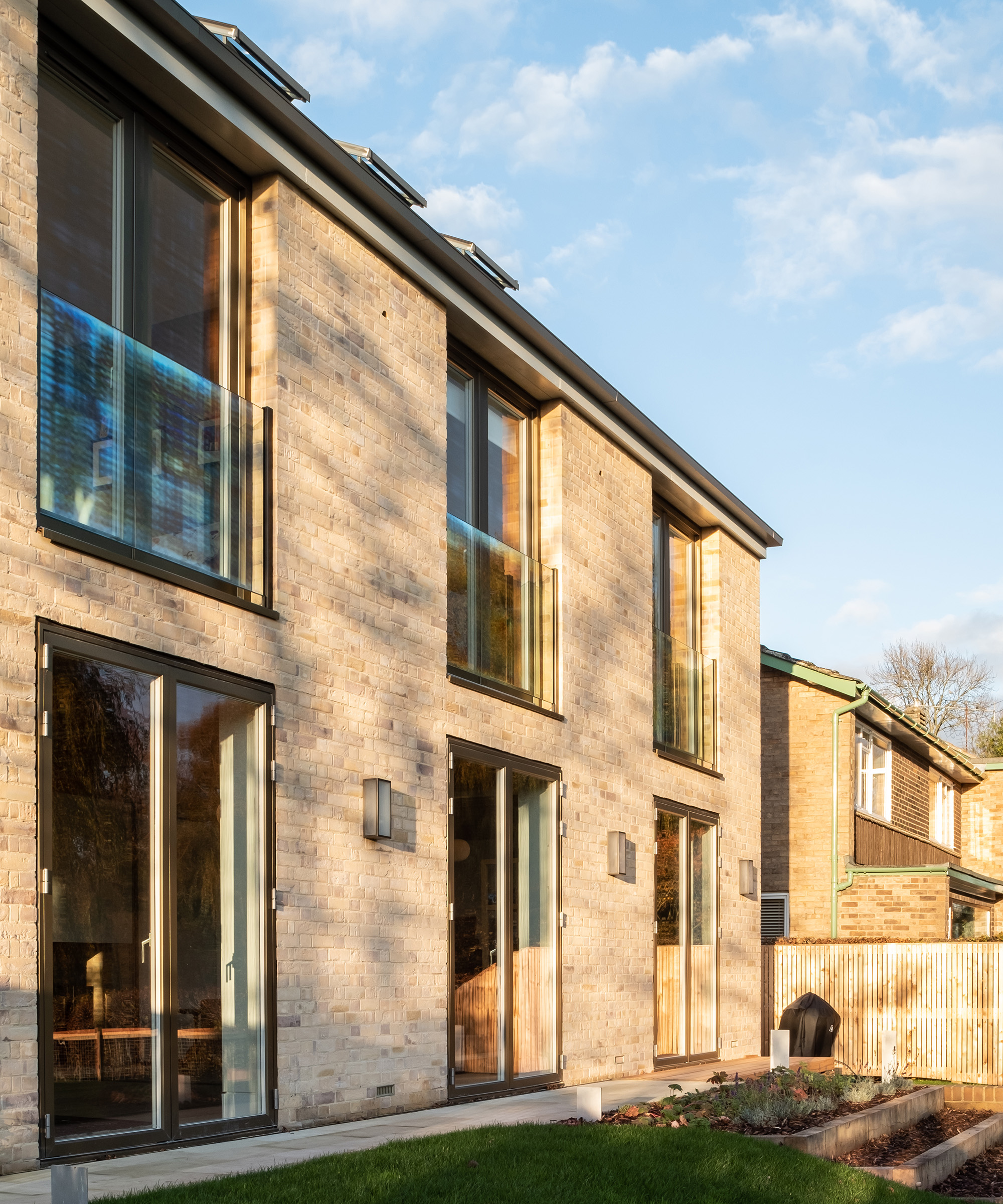 A self build home with brick cladding and a pitched roof with large windows