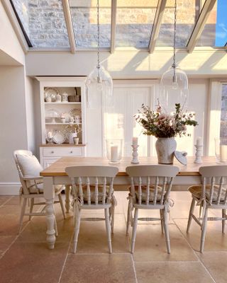 orangery ideas with neutral country decor and glass pendants in dining area