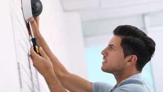 man installing a security camera