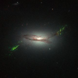 Ghostly green filaments lie within galaxy 2MASX J22014163+1151237, as seen in this new NASA/ESA Hubble Space Telescope image, released April 2, 2015.