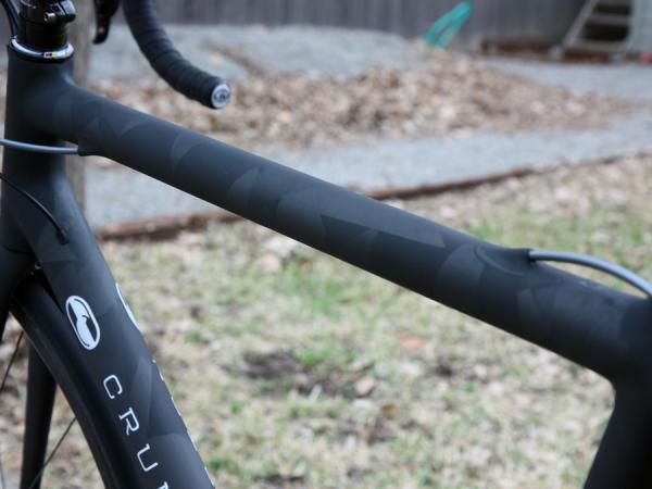The rear brake housing is fed through the top tube of Crumpton's new SL via a stainless steel tube. Small swatches of otherwise wasted unidirectional carbon fiber is applied to the surface for the unique finish.