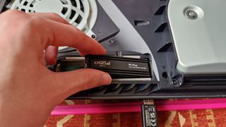 Crucial P5 Plus being inserted into a PS5