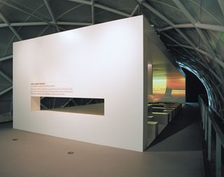 An installation at the Imperial War Museum. A showroom is set like a closed large cubicle with a video playing at the front.