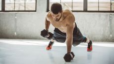 A man performing a renegade row with dumbbells as part of an upper-body workout