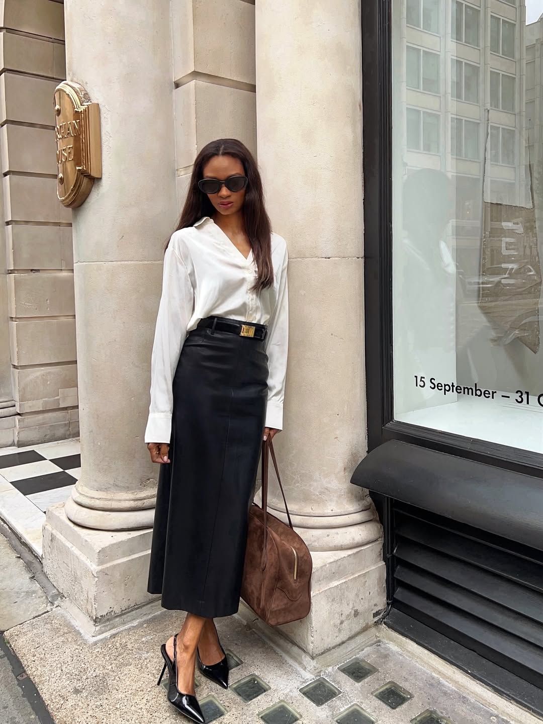 A woman standing on the street wearing the Saint Laurent Vendôme Slingback Pumps.