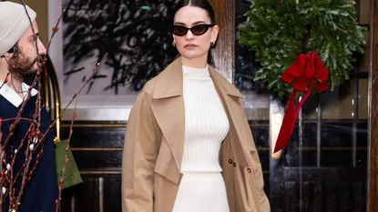 Lily James wearing a cream co-ord and trench coat GettyImages-1866989065