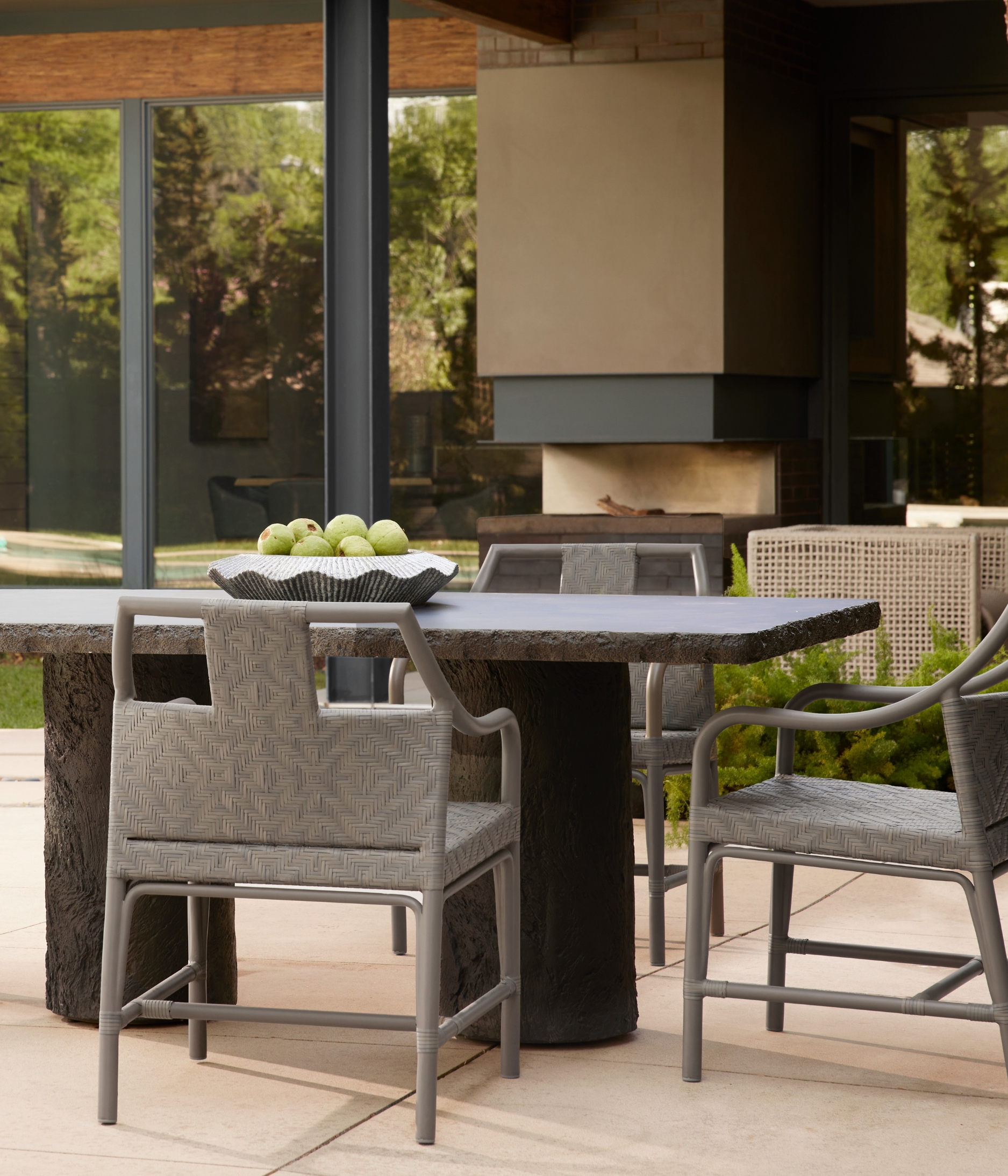 an outdoor table surrounded by grey outdoor chairs in a modern garden