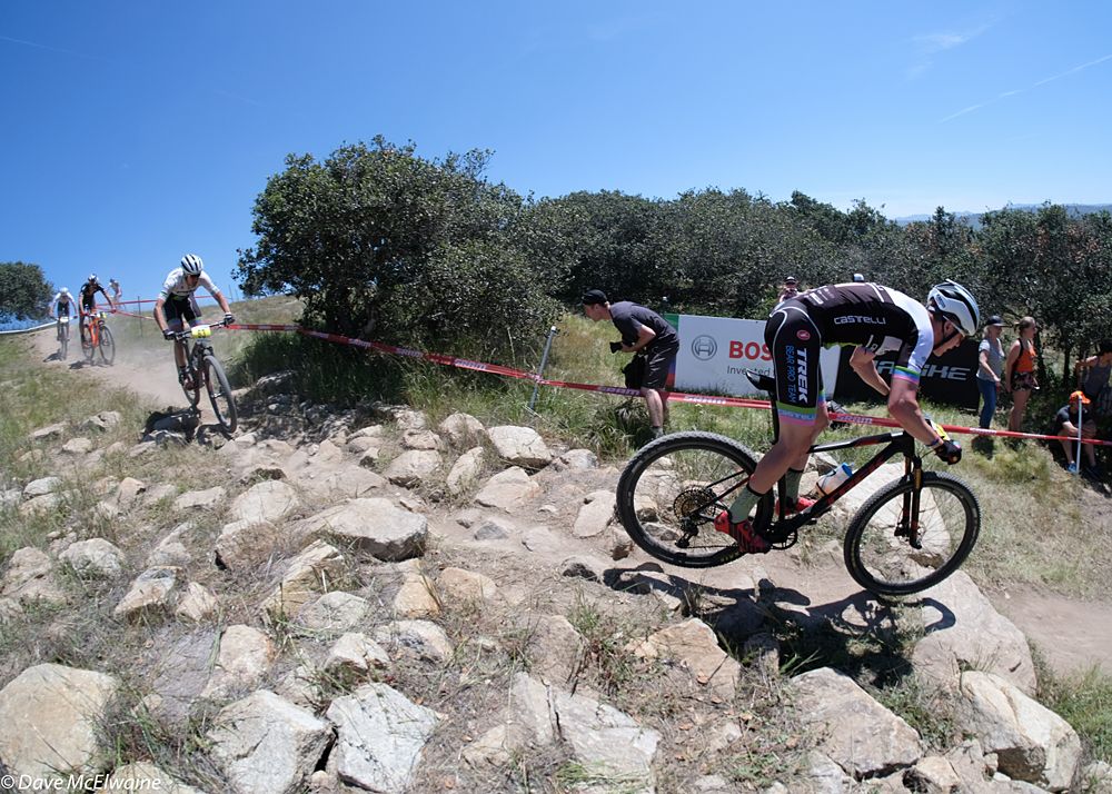 Riders on a fast, rocky descent during the fourth lap