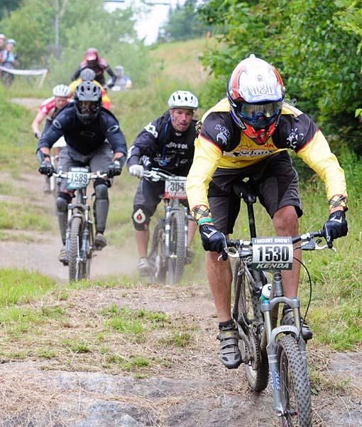 Age group racers head down a drop-off near the top of the mountain.