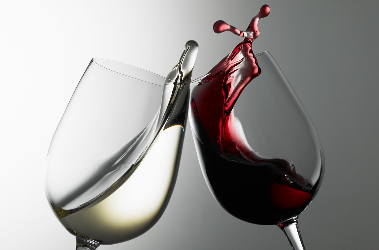 Glass of white wine and glass of red wine clinking