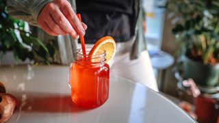 A woman making a special non-alcoholic drink with a garnish