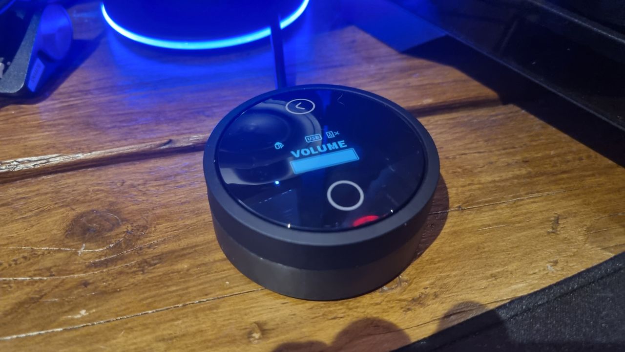The SteelSeries Arena 9 hockey puck controller with OLED display, in this case showing volume control settings