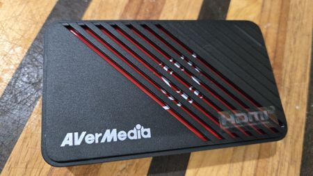 An AverMedia external capture card on a chair.
