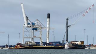 A SpaceX Falcon 9 booster returns to shore with a lean, on Nov. 19, 2020.