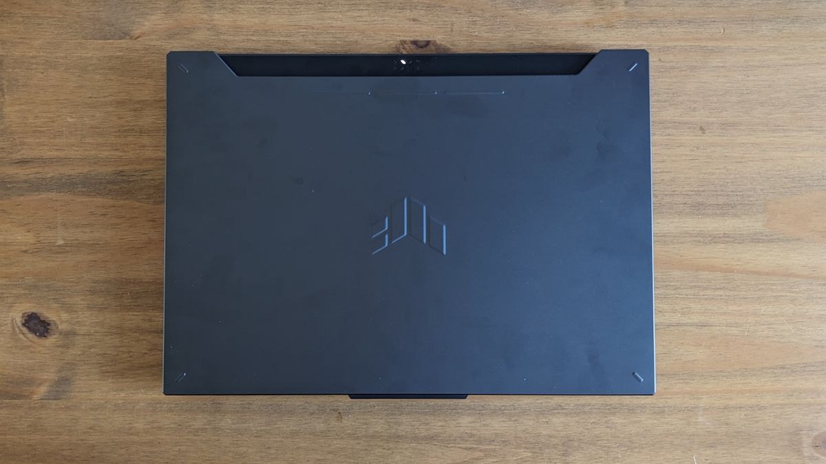 A black ASUS TUF Gaming A15 laptop on a wooden table