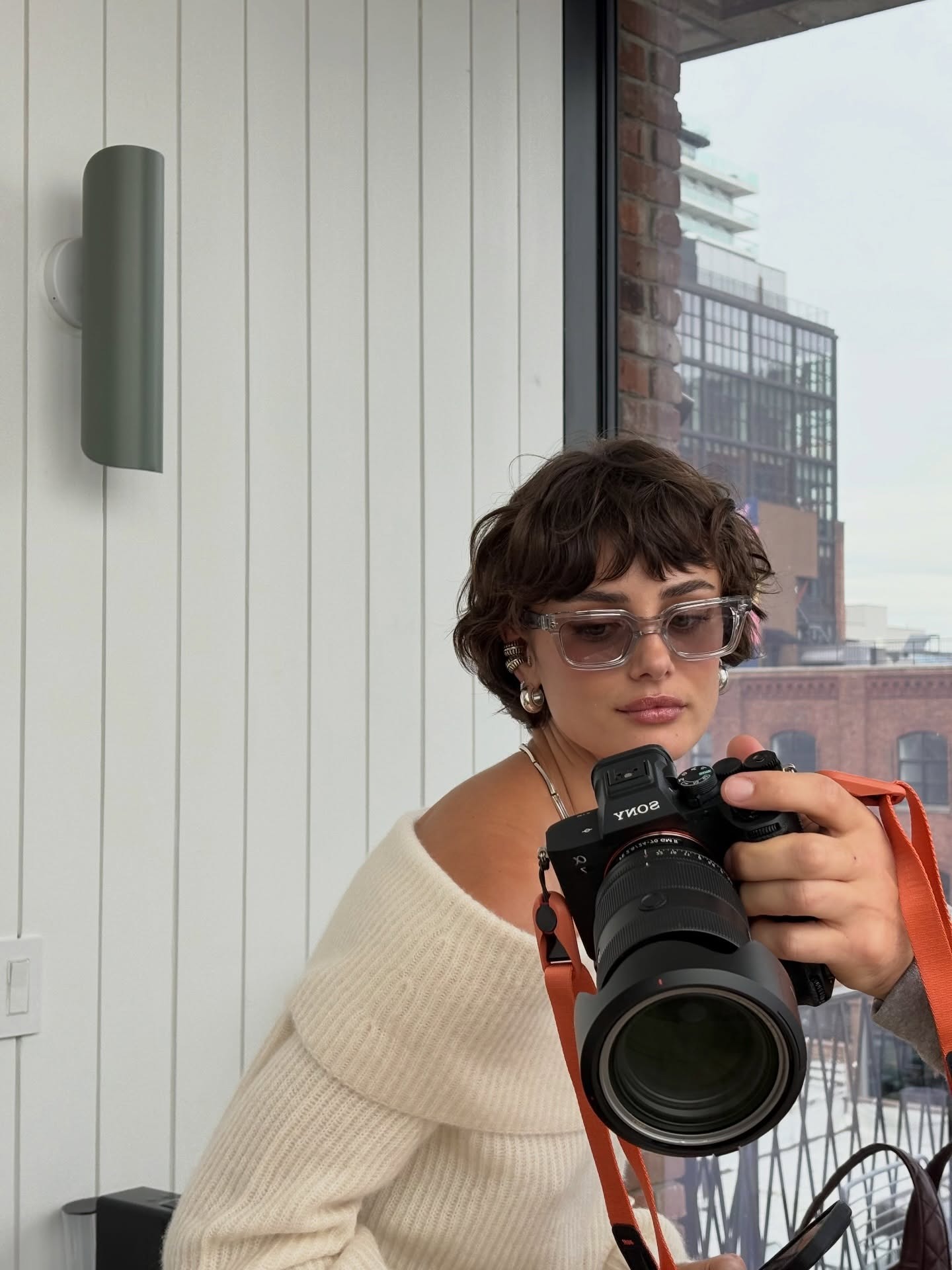 Taylor Hill looking into a camera with a curly bob hairstyle and fringe