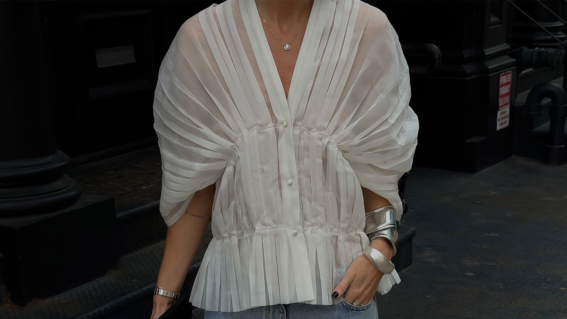 @hannahlewisstylist outfit closeup in a white pleated blouse and baggy blue jeans