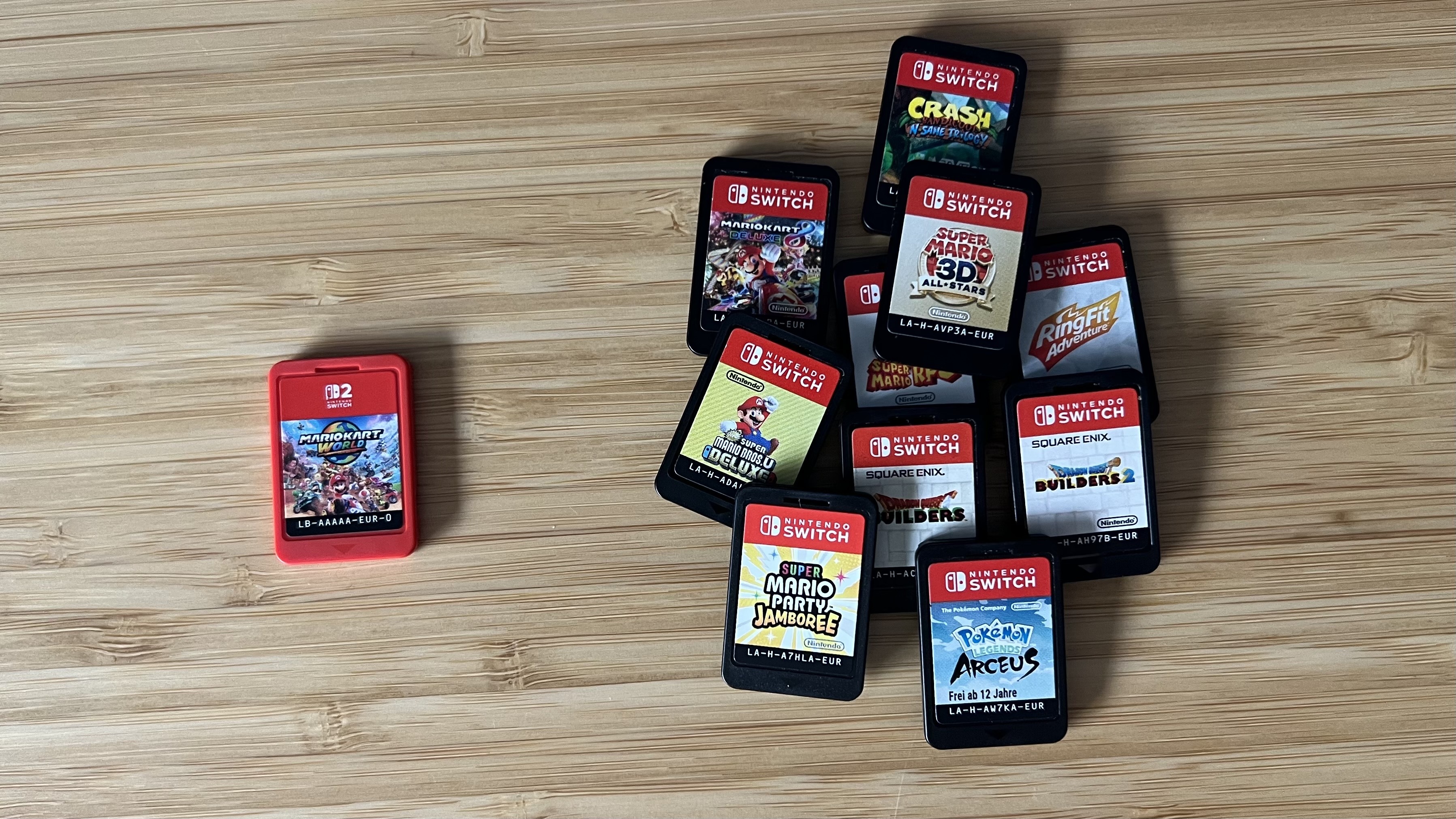 Mario Kart World game cartridge next to a bundle of Nintendo Switch games