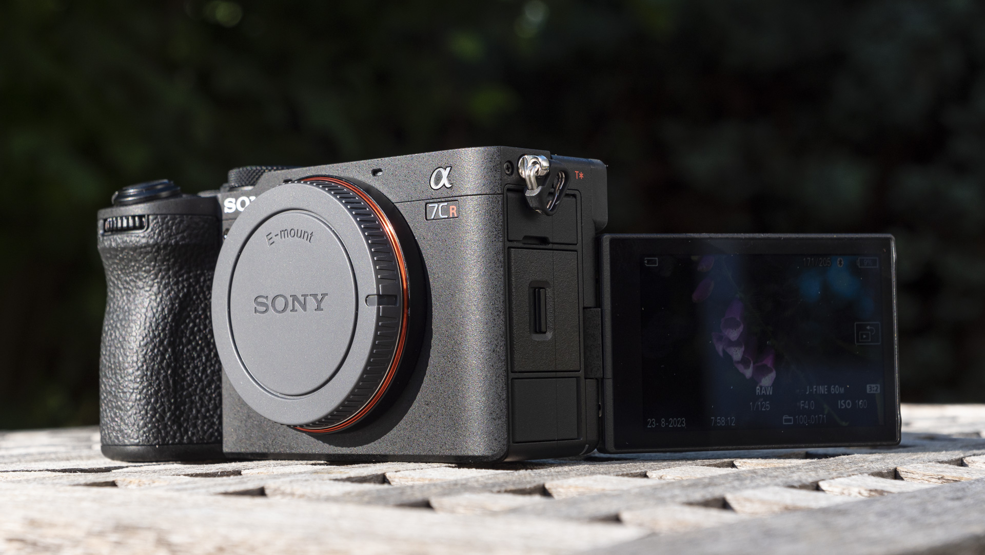 Sony A7C R mirrorless camera with touchscreen flipped out, outside on a wooden table