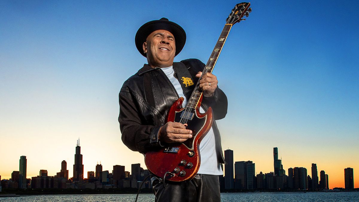 A photo of Ronnie Baker Brooks playing his 1967 Gibson SG with the Chicago skyline behind him