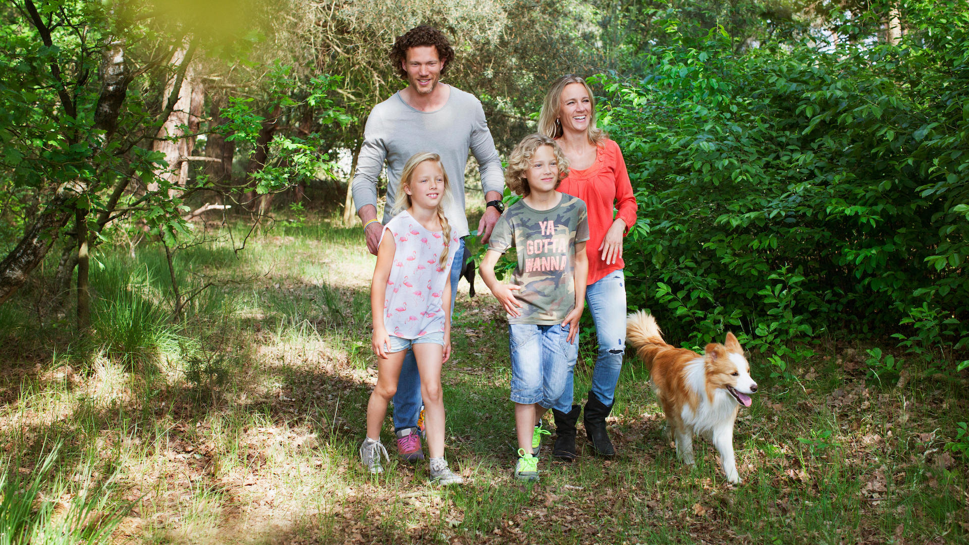 Family with two kids walking happy dog