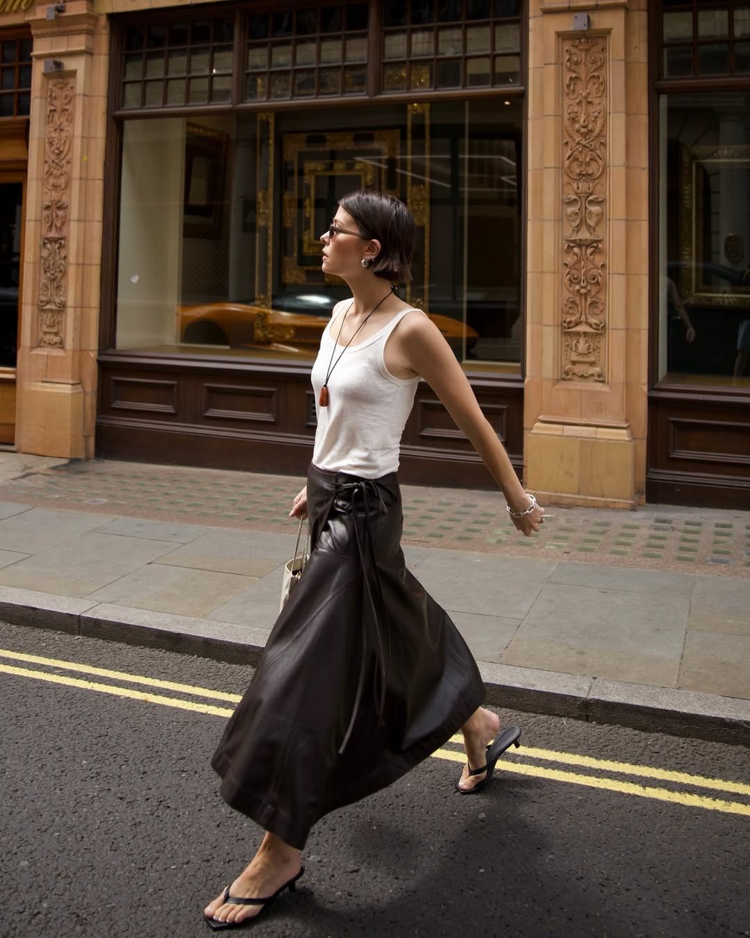 Alice Satterthwaite wears a white tank top, brown maxi skirt and flip flop heels: best bottoms to wear with flip-flop heels 2026