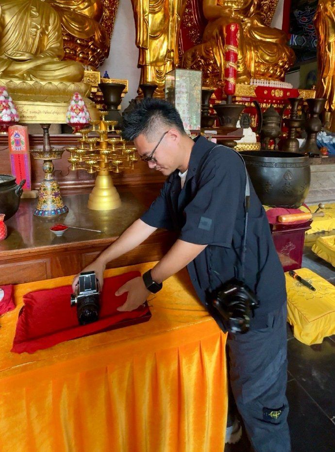 A Buddhist monk blesses a Hasselblad film camera at the Shaolin Temple in Henan, China
