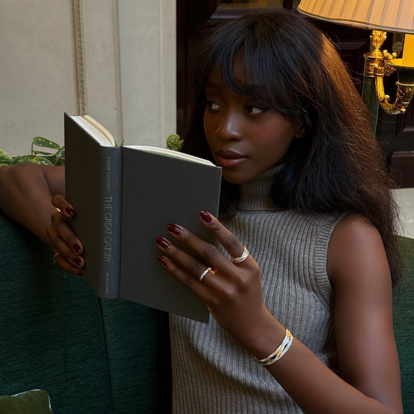 Photo of @emmanuellek_ reading a book in moody lighting 