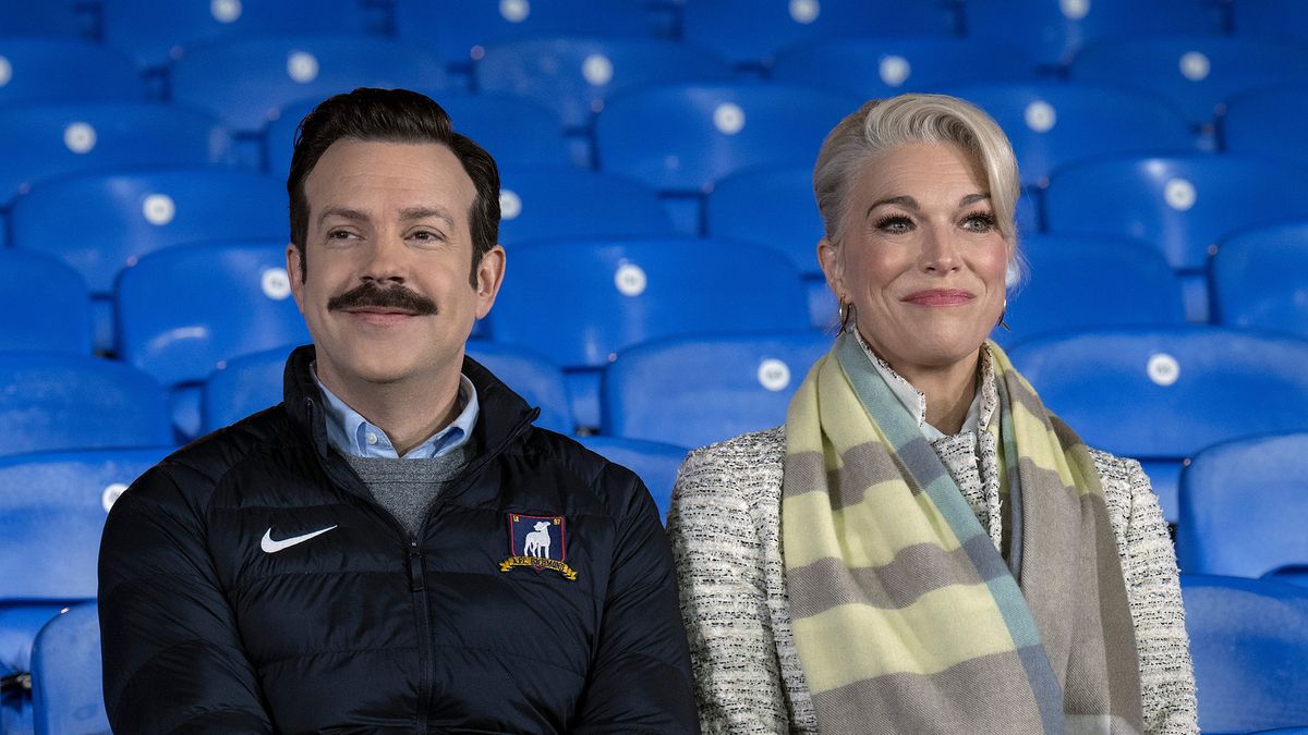 (L, R) Jason Sudeikis as Ted Lasso and Hannah Waddingham as Rebecca Waddingham sit together in the Richmond stands in Ted Lasso season 3 episode 12, &quot;So Long, Farewell&quot;