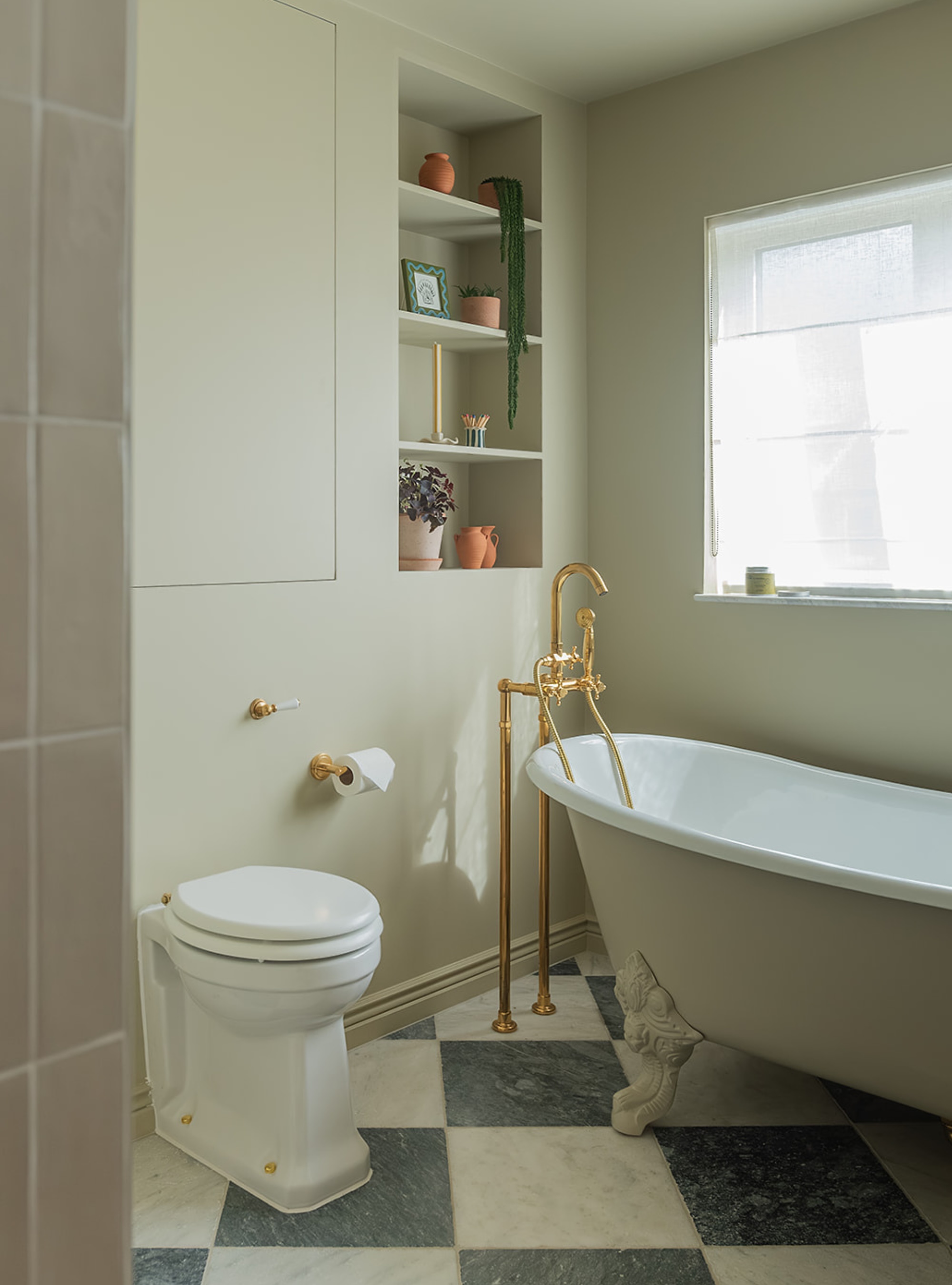 Sage green bathroom with hidden cupboard in wall