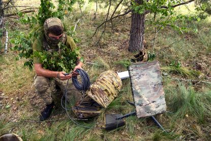 Ukrainian soldier sets up Starlink terminal