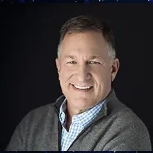 A middle aged man is smiling.