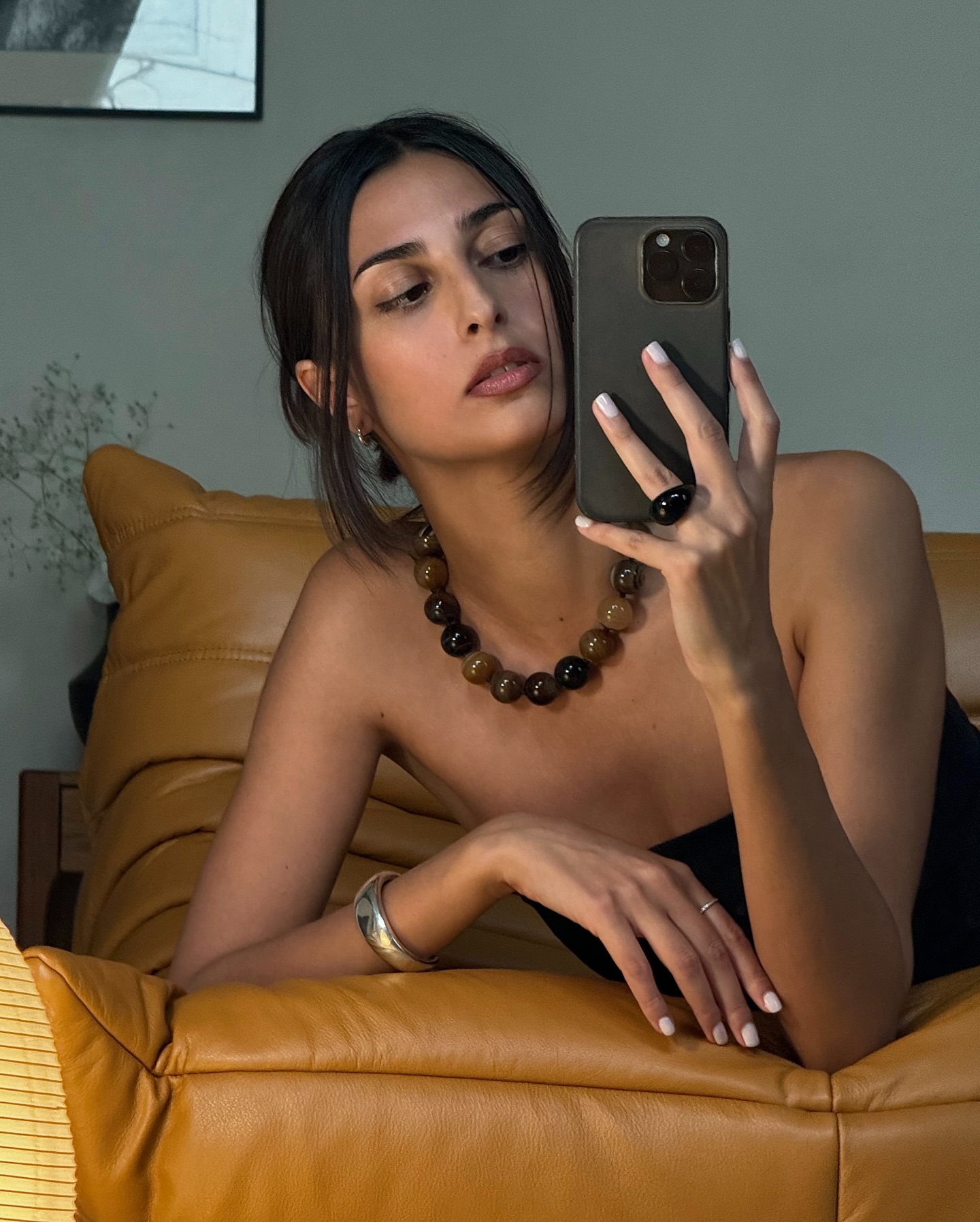 Salome Mory taking a selfie in the mirror with her nails painted a milky white colour