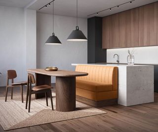 Modern kitchen dining area with a tan upholstered banquette, fluted wooden table, sleek dark cabinetry, and black pendant lighting, creating a stylish, contemporary space.