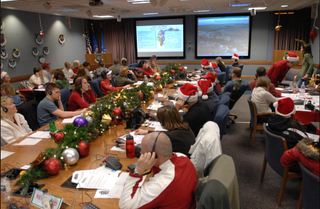 A festive room filled with people tracking Santa Claus