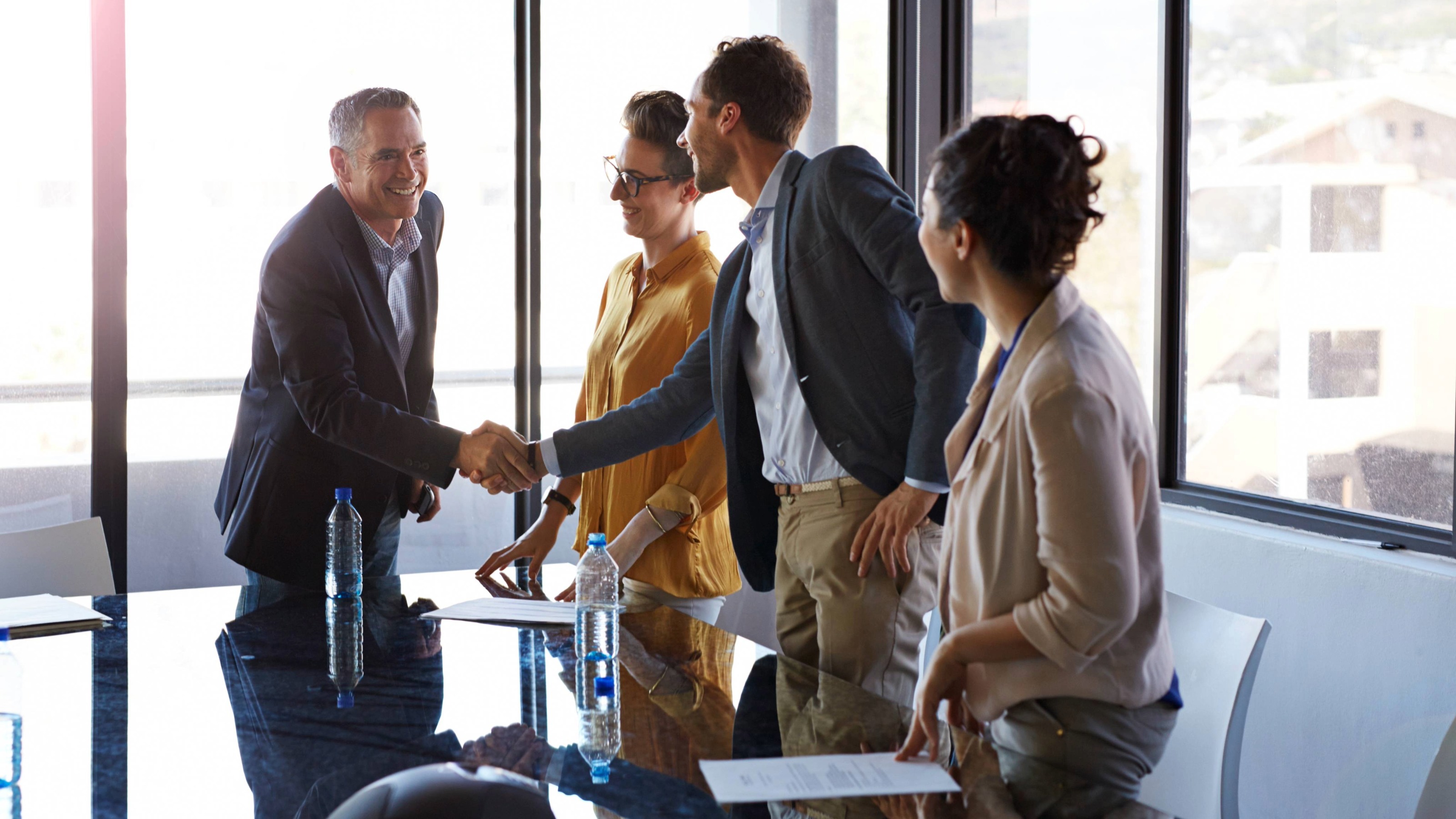 Businesspeople shaking hands in conference room