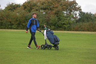 Dan Parker walking the golf course with the VEssel Lux Xv 2.0 cart bag on an electric trolley