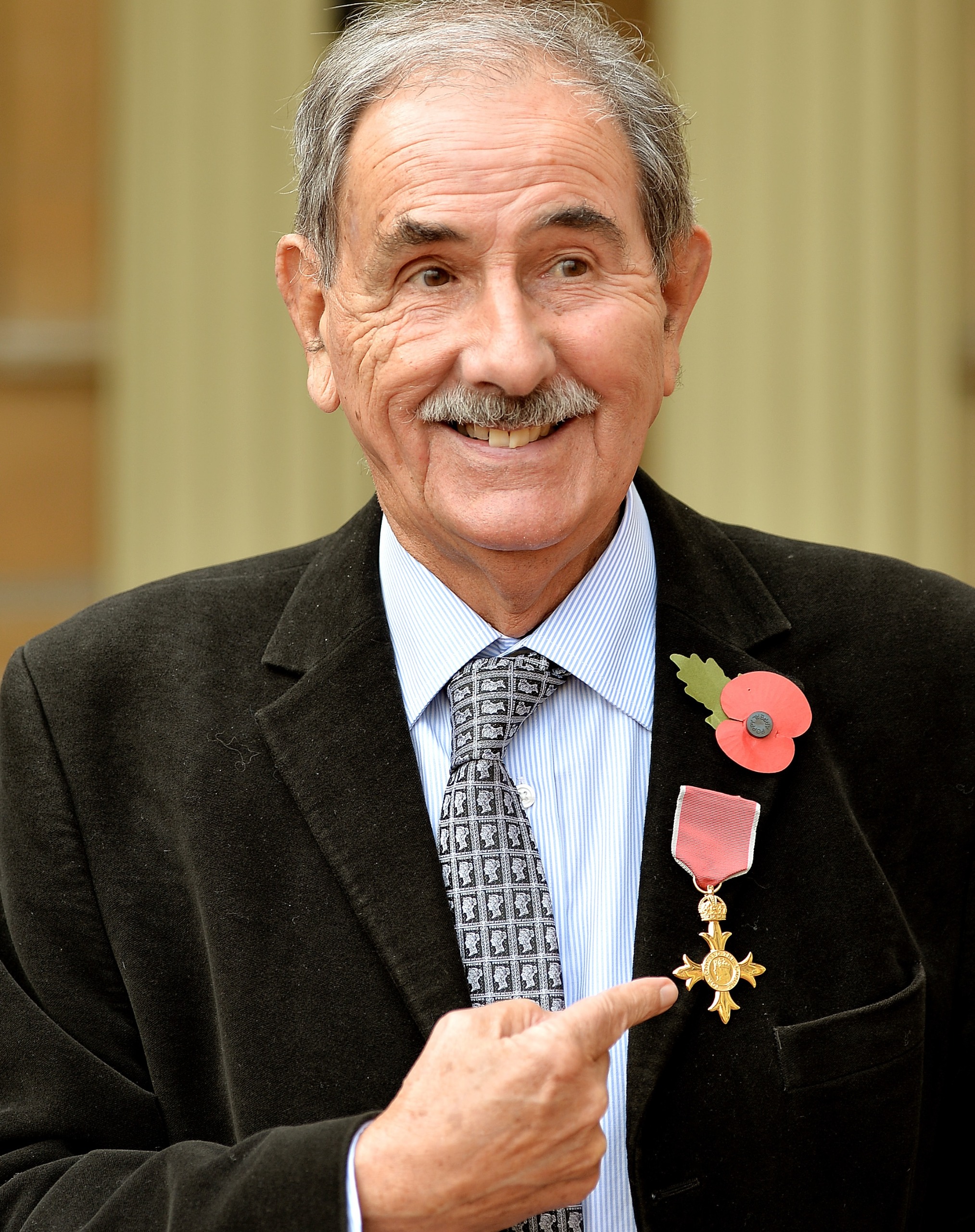 Author Hunter Davies wears his Officer of the Order of the British Empire (OBE) medal after the Investiture ceremony at Buckingham Palace on November 11, 2014