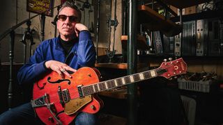 Portrait of Richard Hawley in sunglasses with his vintage Gretsch guitars